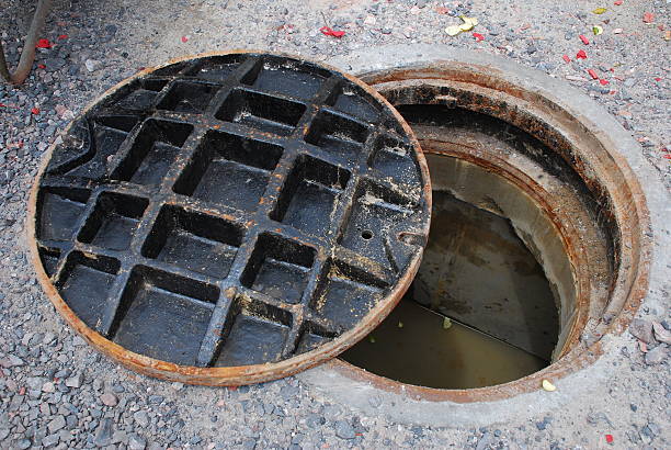 Partially open manhole on a street with water/sewage visible below marmaraereğlisi rögar açma
